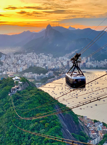 Teleférico subiendo al Pan de Azúcar en Río de Janeiro al atardecer con vistas panorámicas de la ciudad.